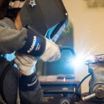 Student welding a collision repair part in the shop