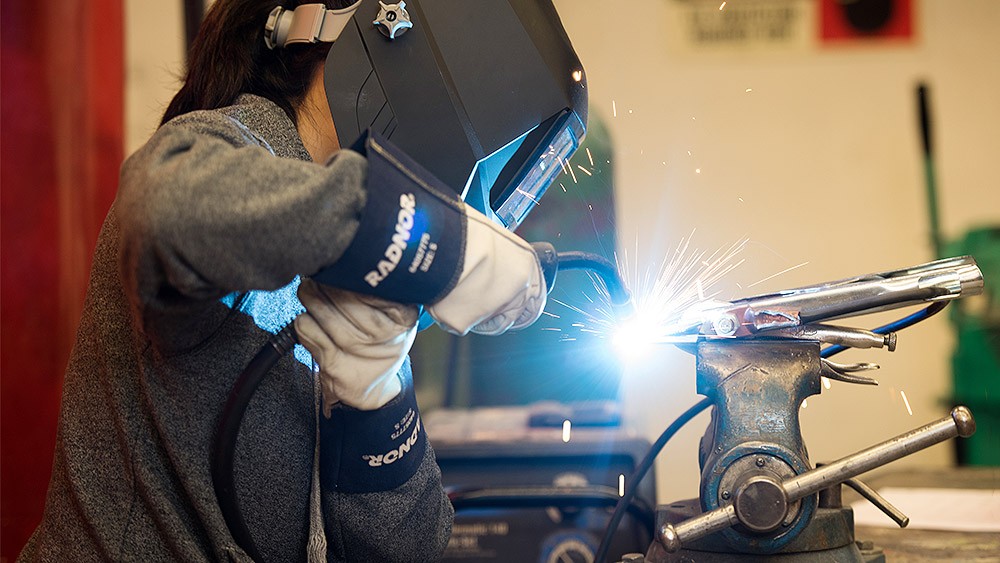 Student welding a collision repair part in the shop