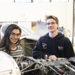 Students working on car engines in an automotive technology program, demonstrating hands-on learning and skill development.