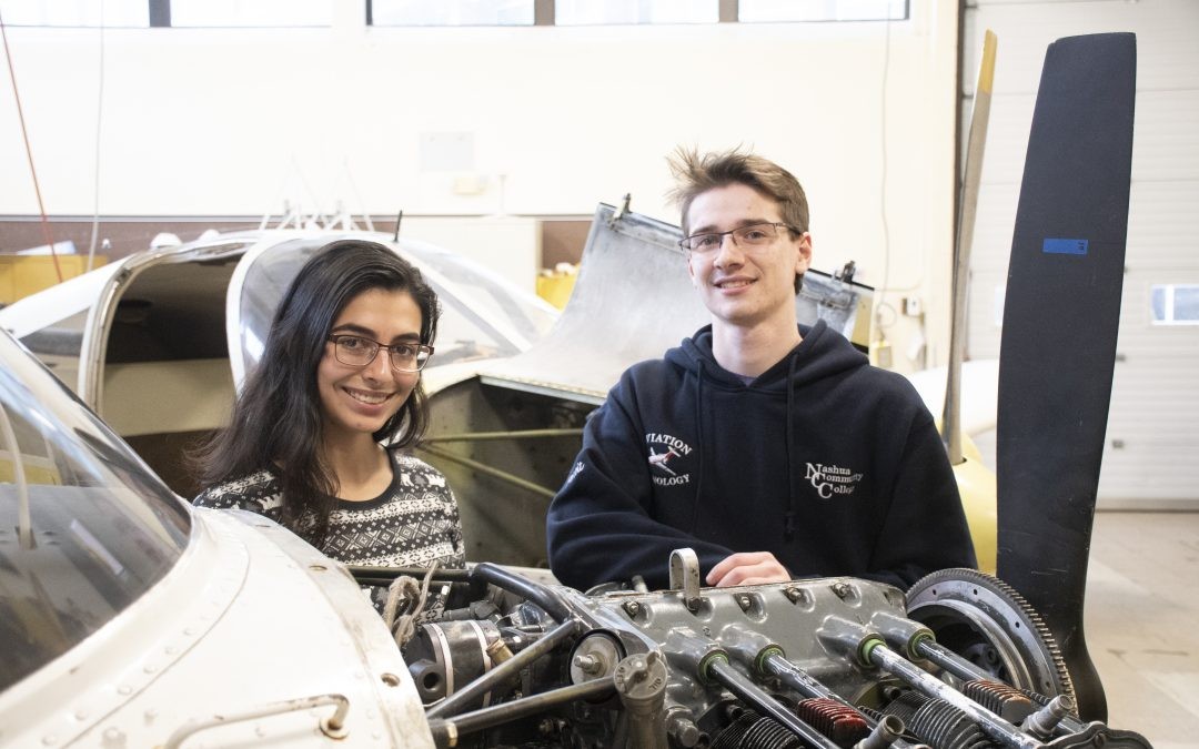 Students working on car engines in an automotive technology program, demonstrating hands-on learning and skill development.