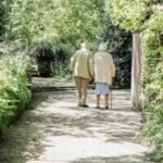 Smiling elderly couple sitting together, representing family caregiving