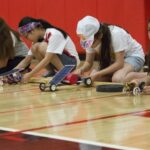 Students participating in the Junior Solar Sprint race, showcasing their designed solar cars.